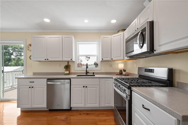 108 Mary St, Ross Twp, PA 15214 - kitchen featuring appliances with stainless steel finishes, white cabinets, crown molding, light wood finished floors, and recessed lighting
