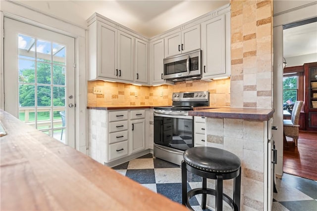 2026 Darlington Rd, Chippewa Twp, PA 15010 - kitchen with appliances with stainless steel finishes, tile patterned floors, healthy amount of natural light, and decorative backsplash