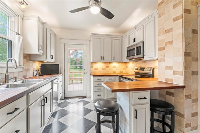 2026 Darlington Rd, Chippewa Twp, PA 15010 - kitchen featuring wooden counters, appliances with stainless steel finishes, a kitchen breakfast bar, and dark floors