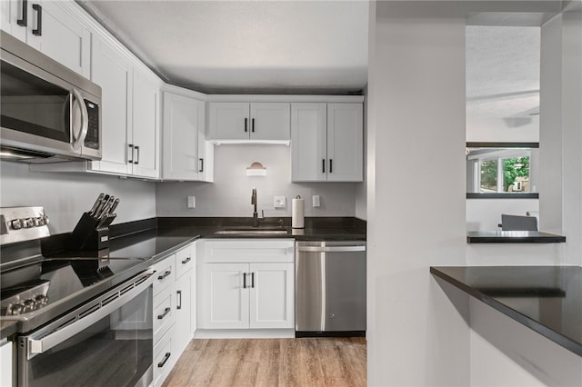 6013 Patrick Henry, Hopewell Twp Bea, PA 15001 - kitchen with stainless steel appliances, light wood-type flooring, dark countertops, and white cabinetry