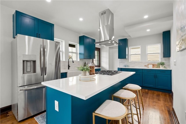 1738 Barr Ave, Crafton, PA 15205 - kitchen with appliances with stainless steel finishes, blue cabinetry, island exhaust hood, tasteful backsplash, and a kitchen breakfast bar