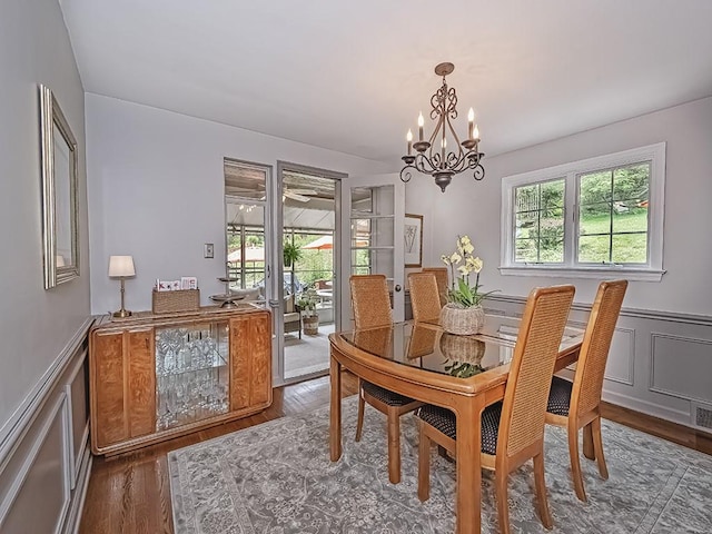 776 Elm Spring Rd, Mt Lebanon, PA 15243 - dining room with a chandelier, a wainscoted wall, wood finished floors, and a decorative wall
