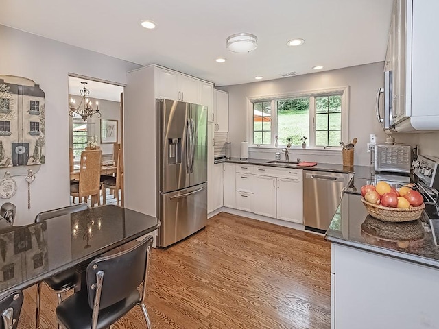 776 Elm Spring Rd, Mt Lebanon, PA 15243 - kitchen with appliances with stainless steel finishes, a chandelier, light wood-type flooring, white cabinetry, and recessed lighting