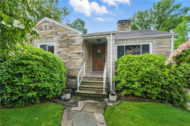 110 Simon Ave, Ross Twp, PA 15237 - view of front of home featuring stone siding, a front yard, and a chimney