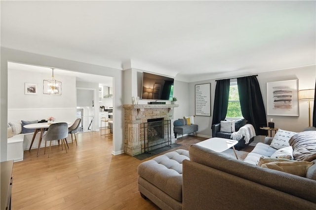 110 Simon Ave, Ross Twp, PA 15237 - living room with light wood-type flooring, a chandelier, and a fireplace with flush hearth