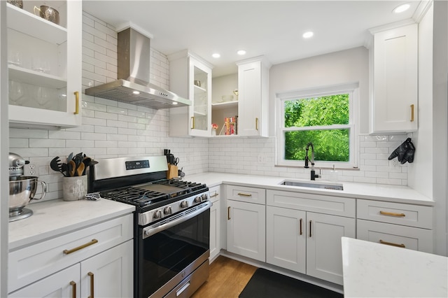 110 Simon Ave, Ross Twp, PA 15237 - kitchen featuring stainless steel range with gas cooktop, wall chimney range hood, white cabinets, glass insert cabinets, and light wood-type flooring