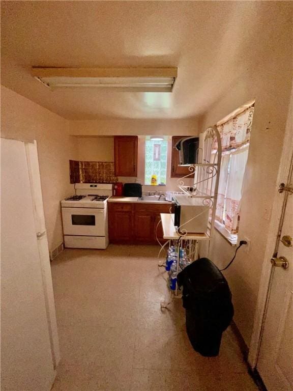 242 Chester Ave, Perry Hilltop, PA 15214 - kitchen with white range with gas stovetop, brown cabinets, and a textured ceiling