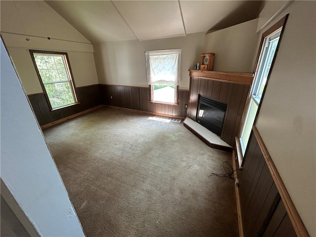 19 Wickhaven Hollow Rd, Perry Twp Fay, PA 15492 - unfurnished living room with a wainscoted wall, a glass covered fireplace, lofted ceiling, carpet, and wood walls