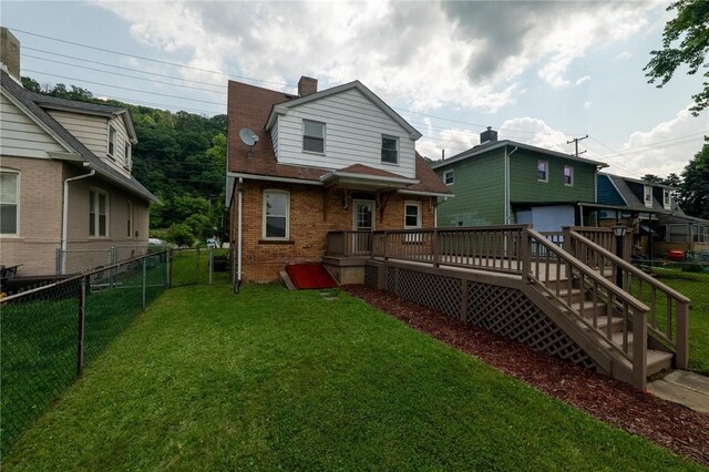 347 Washington St, Leetsdale, PA 15056 - back of property featuring a fenced backyard, a wooden deck, brick siding, a chimney, and a garage