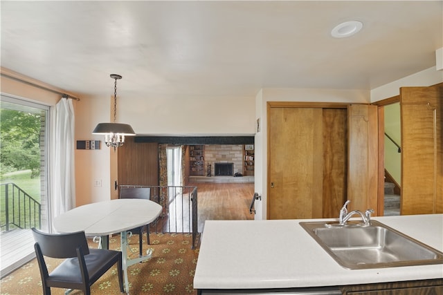 480 Herbst Manor Rd, Kennedy Twp, PA 15108 - kitchen with a fireplace, a chandelier, decorative light fixtures, wood finished floors, and light countertops