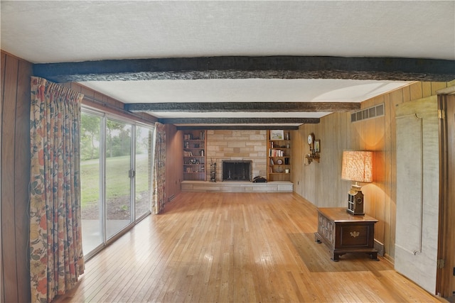 480 Herbst Manor Rd, Kennedy Twp, PA 15108 - unfurnished living room featuring light wood-style floors, wood walls, beam ceiling, and a fireplace