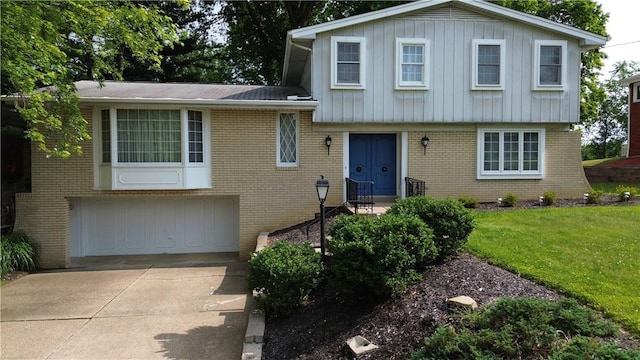 480 Herbst Manor Rd, Kennedy Twp, PA 15108 - tri-level home featuring brick siding, a garage, concrete driveway, a front lawn, and board and batten siding