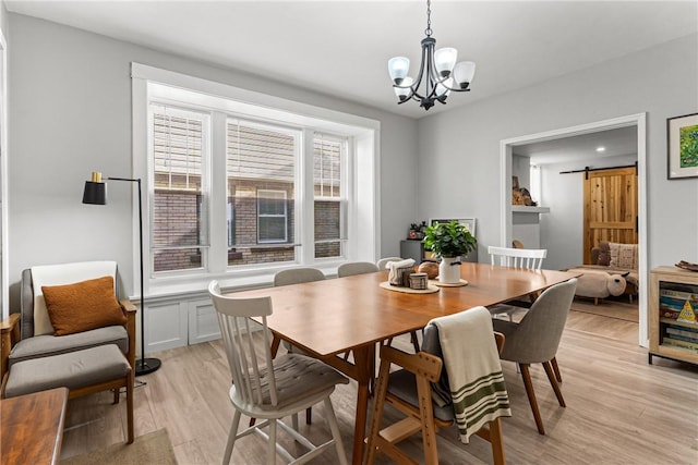 5719 Hobart St, Squirrel Hill, PA 15217 - dining space with light wood-style flooring, a barn door, and a chandelier
