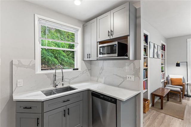 5719 Hobart St, Squirrel Hill, PA 15217 - kitchen with appliances with stainless steel finishes, gray cabinetry, light wood-style floors, backsplash, and light stone counters