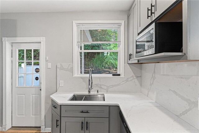 5719 Hobart St, Squirrel Hill, PA 15217 - kitchen featuring gray cabinetry, stainless steel microwave, light stone counters, and tasteful backsplash