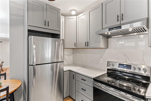 5719 Hobart St, Squirrel Hill, PA 15217 - kitchen with appliances with stainless steel finishes, exhaust hood, gray cabinetry, tasteful backsplash, and light stone countertops