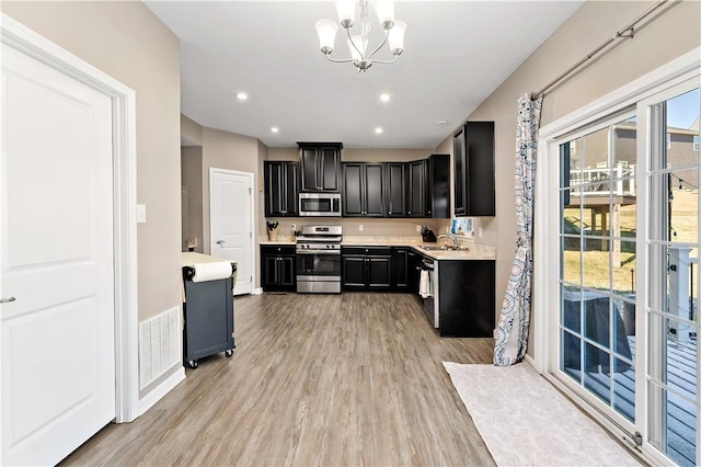 159 Horseshoe Dr, North Fayette, PA 15071 - kitchen featuring appliances with stainless steel finishes, dark cabinetry, light wood finished floors, light countertops, and plenty of natural light