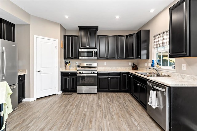 159 Horseshoe Dr, North Fayette, PA 15071 - kitchen with stainless steel appliances, dark cabinetry, light countertops, light wood finished floors, and recessed lighting