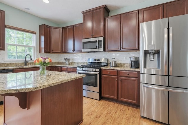 2972 Cross Creek Ct, Hampton, PA 15044 - kitchen with stainless steel appliances, light wood-style flooring, light stone countertops, a kitchen island, and recessed lighting