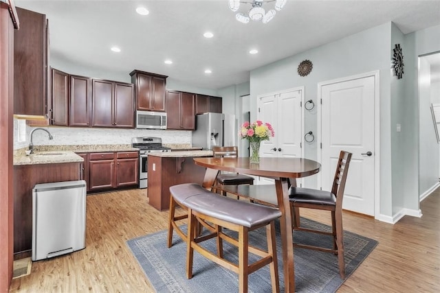 2972 Cross Creek Ct, Hampton, PA 15044 - kitchen with appliances with stainless steel finishes, light wood-style flooring, backsplash, recessed lighting, and light stone counters