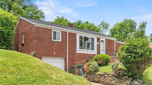 5330 Cox Ave, Lincoln Place, PA 15207 - view of home's exterior featuring brick siding, a chimney, an attached garage, and a yard