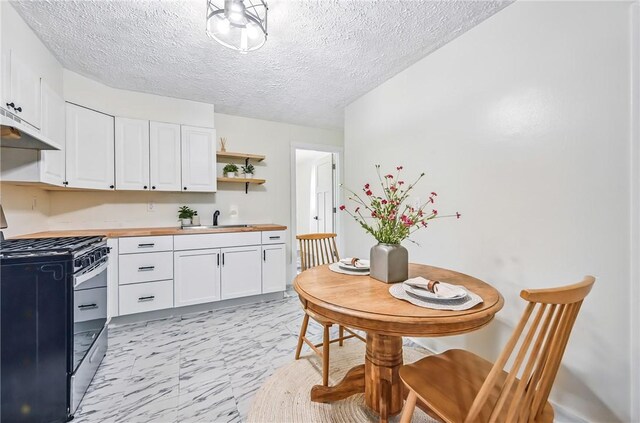 209 George St, Farrell, PA 16121 - kitchen with black gas stove, wood counters, a textured ceiling, white cabinetry, and light marble finish flooring