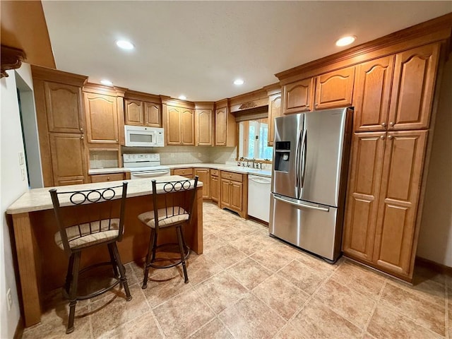 155 Anoka, Neshannock Twp, PA 16105 - kitchen with white appliances, a peninsula, a kitchen breakfast bar, light countertops, and tasteful backsplash