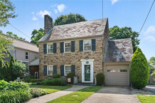 517 Keystone Dr, New Kensington, PA 15068 - colonial house featuring stone siding, a chimney, a high end roof, and driveway