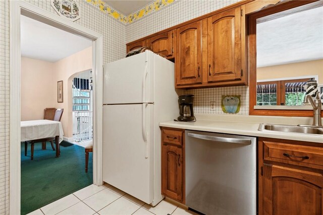 517 Keystone Dr, New Kensington, PA 15068 - kitchen featuring dishwasher, freestanding refrigerator, brown cabinetry, wallpapered walls, and light countertops