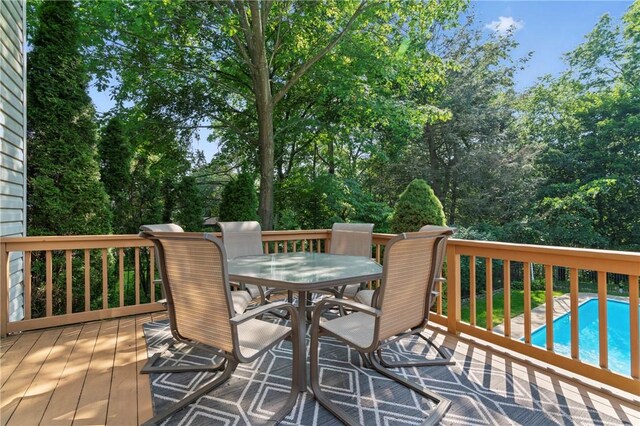 517 Keystone Dr, New Kensington, PA 15068 - wooden deck with outdoor dining space, an outdoor pool, and view of wooded area