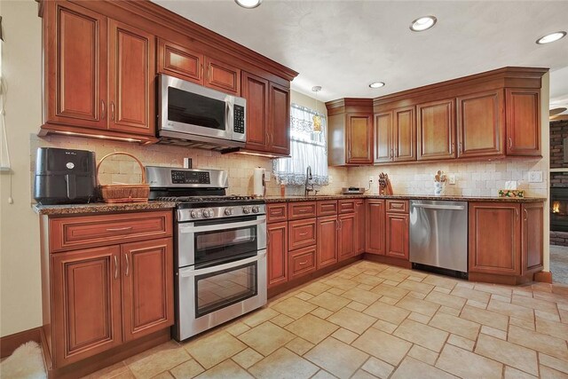 2684 3rd St, Monroeville, PA 15146 - kitchen featuring stainless steel appliances, dark stone counters, recessed lighting, light stone finish flooring, and decorative backsplash