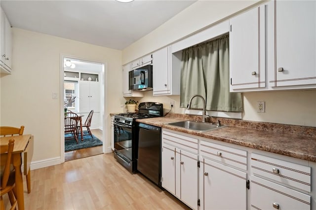 1333 Windermere Dr, Squirrel Hill, PA 15218 - kitchen featuring black appliances, light wood-type flooring, and white cabinetry