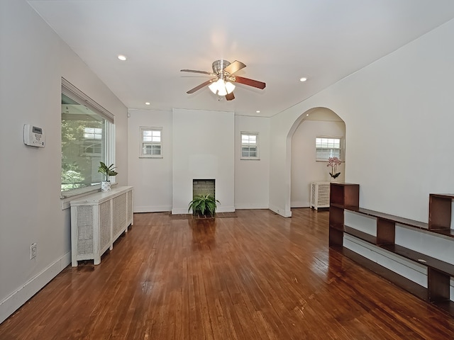 6656 Wilkins Ave, Squirrel Hill, PA 15217 - unfurnished living room featuring a ceiling fan, a fireplace, wood-type flooring, arched walkways, and recessed lighting