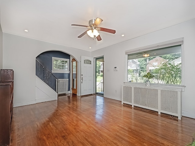 6656 Wilkins Ave, Squirrel Hill, PA 15217 - foyer with arched walkways, a ceiling fan, wood finished floors, stairs, and radiator heating unit