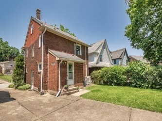 6656 Wilkins Ave, Squirrel Hill, PA 15217 - view of front facade with a chimney, a front lawn, brick siding, and a patio