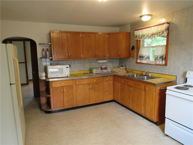 1764 Rose St, Lower Burrell, PA 15068 - kitchen featuring white appliances, brown cabinetry, and decorative backsplash