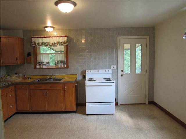 1764 Rose St, Lower Burrell, PA 15068 - kitchen with electric stove, brown cabinetry, light flooring, and dark countertops