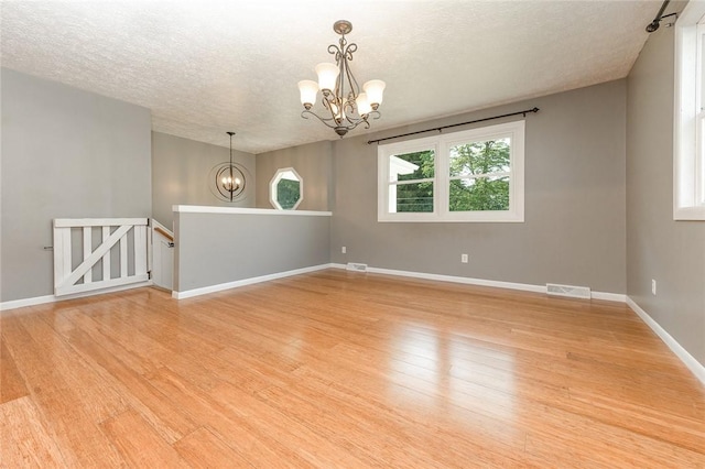 453 Falls Ave, Neshannock Twp, PA 16105 - empty room with a chandelier, a textured ceiling, and light wood-type flooring