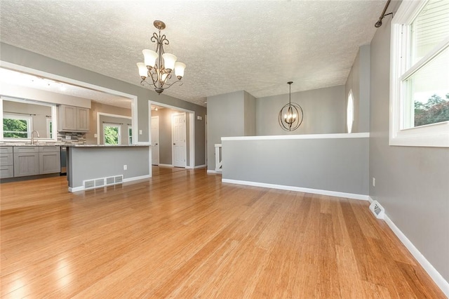 453 Falls Ave, Neshannock Twp, PA 16105 - unfurnished living room featuring a chandelier, a textured ceiling, and light wood-style floors