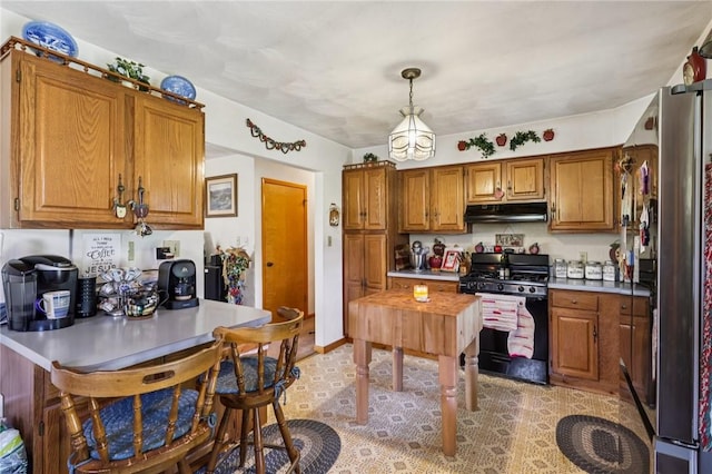 379 Airport Rd, Worthington, PA 16262 - kitchen with gas stove, freestanding refrigerator, under cabinet range hood, brown cabinets, and light countertops