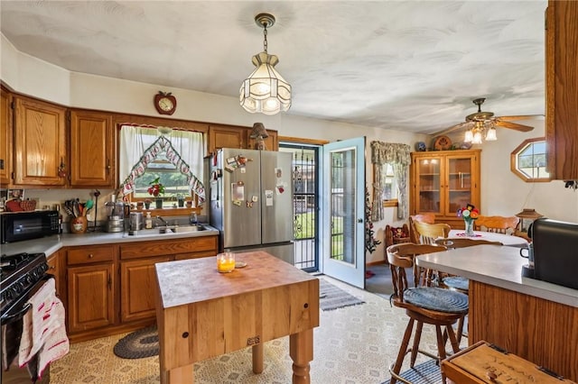379 Airport Rd, Worthington, PA 16262 - kitchen featuring black appliances, light countertops, brown cabinetry, a ceiling fan, and hanging light fixtures