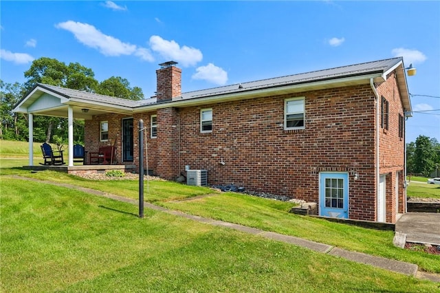 379 Airport Rd, Worthington, PA 16262 - back of property featuring a chimney, brick siding, a yard, an attached garage, and a metal roof