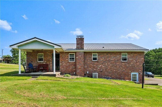 379 Airport Rd, Worthington, PA 16262 - back of house featuring a chimney, a lawn, brick siding, a standing seam roof, and a metal roof