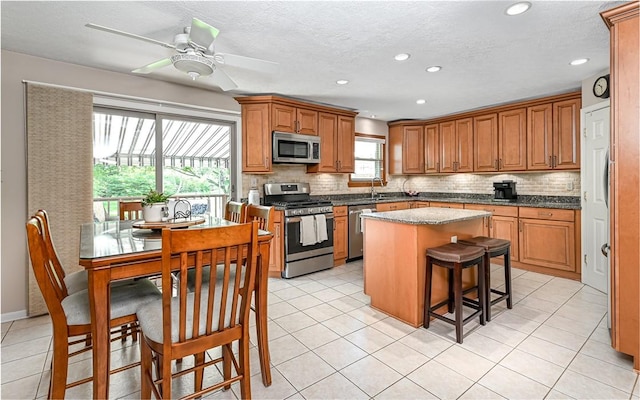 3150 Sundance Ct, Hampton, PA 15101 - kitchen with stainless steel appliances, a center island, backsplash, a ceiling fan, and recessed lighting
