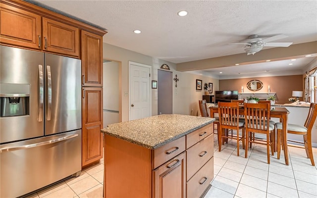 3150 Sundance Ct, Hampton, PA 15101 - kitchen with stainless steel fridge, light tile patterned floors, brown cabinets, a ceiling fan, and a kitchen island