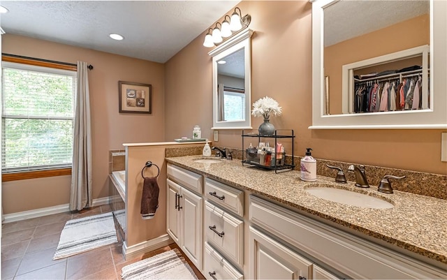 3150 Sundance Ct, Hampton, PA 15101 - bathroom with double vanity, recessed lighting, a tub to relax in, tile patterned flooring, and a walk in closet