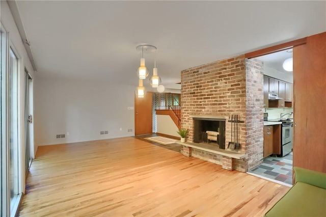 113 S Heide Ln, Peters Twp, PA 15317 - unfurnished living room featuring light wood-style floors and a brick fireplace