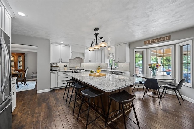 204 Pine Cone Ct, Pine Twp Nal, PA 15090 - kitchen with dark wood-style flooring, a kitchen bar, tasteful backsplash, a center island, and recessed lighting