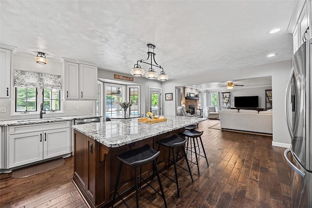 204 Pine Cone Ct, Pine Twp Nal, PA 15090 - kitchen with freestanding refrigerator, dark wood-type flooring, a kitchen island, white cabinetry, and a kitchen breakfast bar