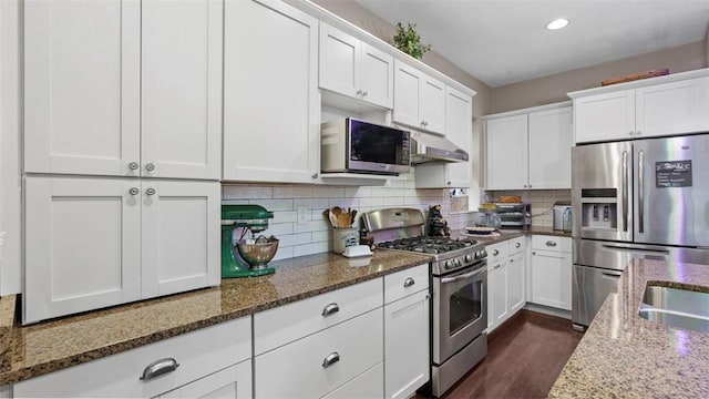 422 S Lang Ave, Point Breeze, PA 15208 - kitchen featuring appliances with stainless steel finishes, white cabinetry, under cabinet range hood, stone counters, and tasteful backsplash